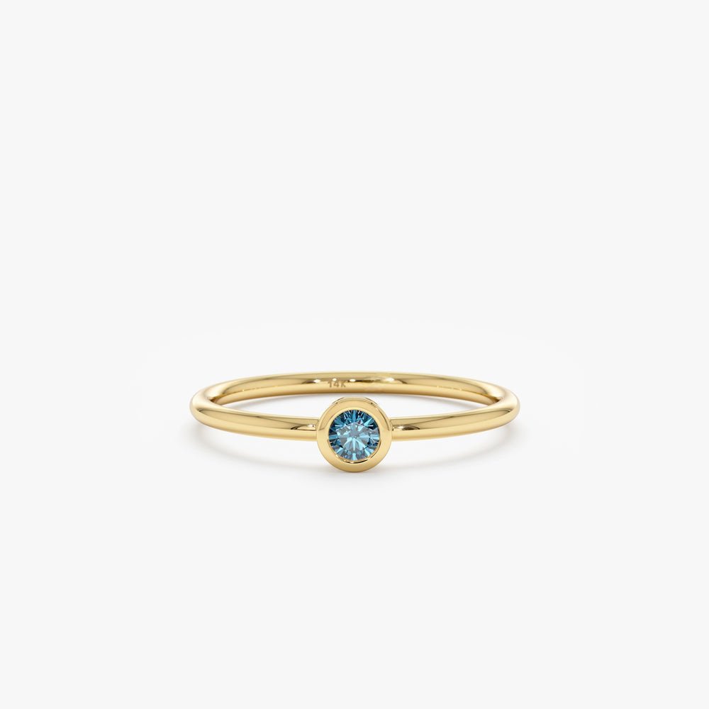 Our Natural Blue Diamond Bezel Ring features a rare and stunning enhanced blue diamond in a modern bezel setting. Handcrafted with solid gold, this dainty ring is perfect for stacking or as an elegant engagement ring.